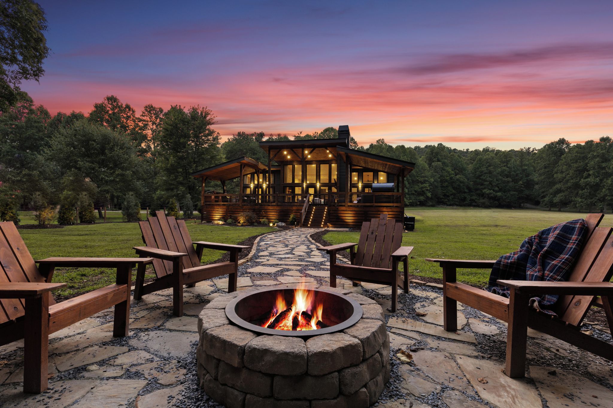 A wooden cabin with a fire pit and outdoor seating.