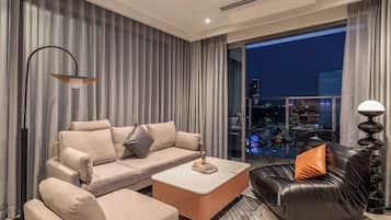 Una sala moderna con un sofá, una mesita de centro y un sillón de cuero.