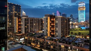 Un edificio residencial de gran altura con varios balcones y vista al río.