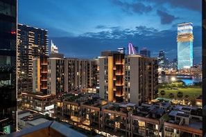 A high-rise residential building with multiple balconies and a river view. - Metropole Riverside Luxury Apartment (Thu Duc)