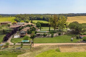 A residential area with multiple houses, a swimming pool, and a large green field.