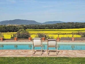 A poolside area with chairs and a view of a countryside landscape. - Historic Catalan farmhouse with pool near Girona (Cornellà del Terri)