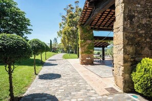 Un chemin de pierre mène à un bâtiment doté d’un espace extérieur abrité.