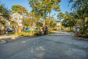 A gated residential area with brick houses, a gated driveway, and a clear sky. - 10% off 3-7 nights thru Dec. 3rd flr. Elev. Pool view. Short walk to beach. (North Myrtle Beach)
