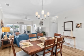 A dining area with a wooden table set for four, surrounded by chairs. - 10% off 3-7 nights thru Dec. 3rd flr. Elev. Pool view. Short walk to beach. (North Myrtle Beach)