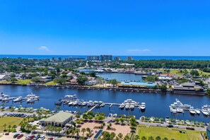 A marina with boats docked, a waterfront promenade, and buildings in the background. - Beachside Bliss. 2nd row Windy Hill. Outdoor pool. Perfect location! (North Myrtle Beach)