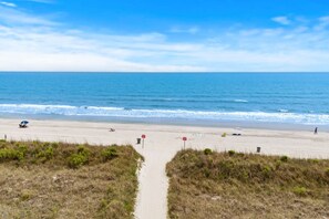 Ein Strand mit einem klaren Weg zum Ufer, gekennzeichnet durch rote Schilder.