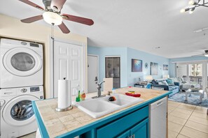 A modern kitchen with a built-in washer, a sink, and a ceiling fan. - Beachside Bliss. 2nd row Windy Hill. Outdoor pool. Perfect location! (North Myrtle Beach)
