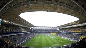 Ein großes Stadion mit mehreren Sitzreihen, einem Spielfeld in der Mitte und einer hohen Decke.
