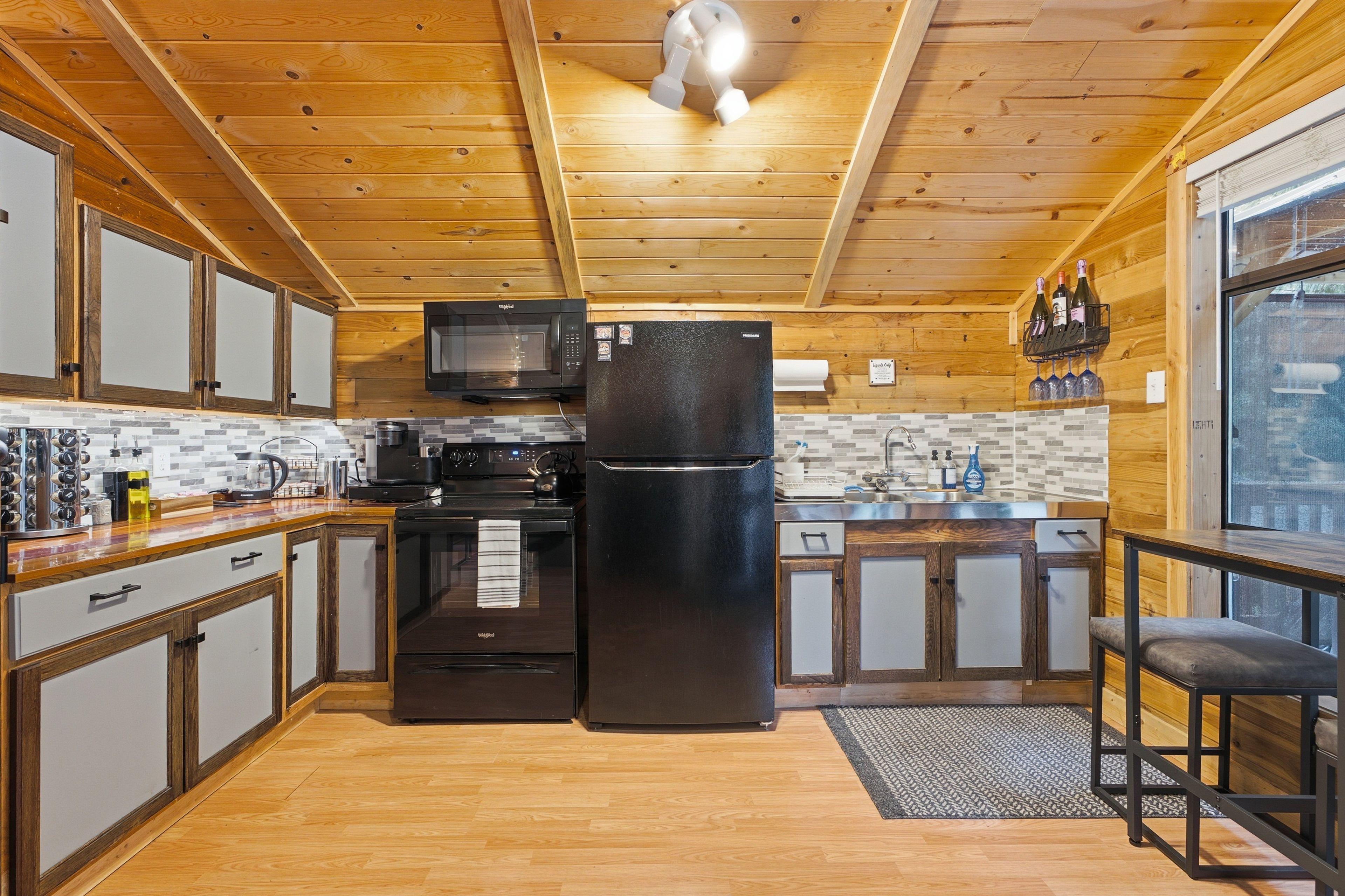 Una cocina compacta con muebles de madera, microondas, refrigerador y cafetera.
