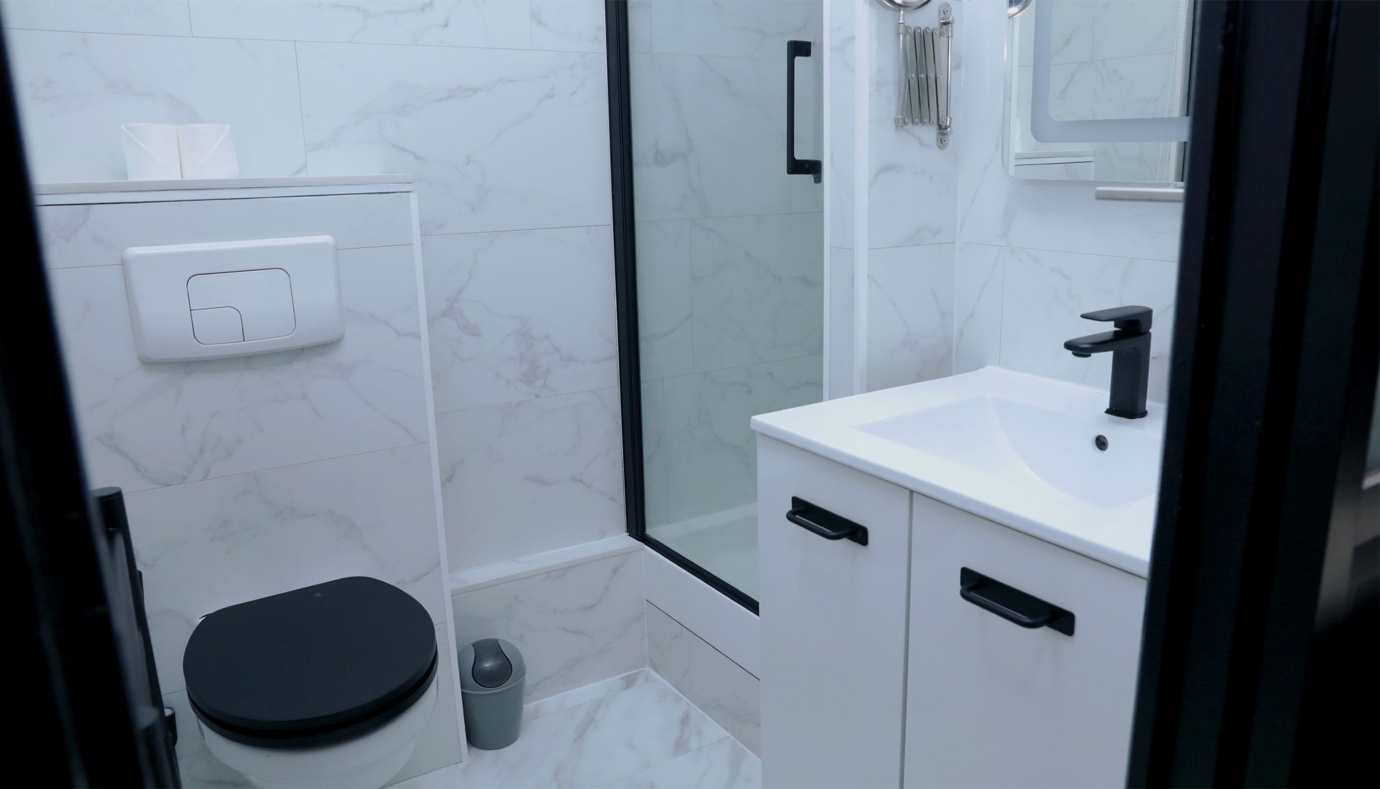 A modern bathroom with a toilet, sink, and shower.
