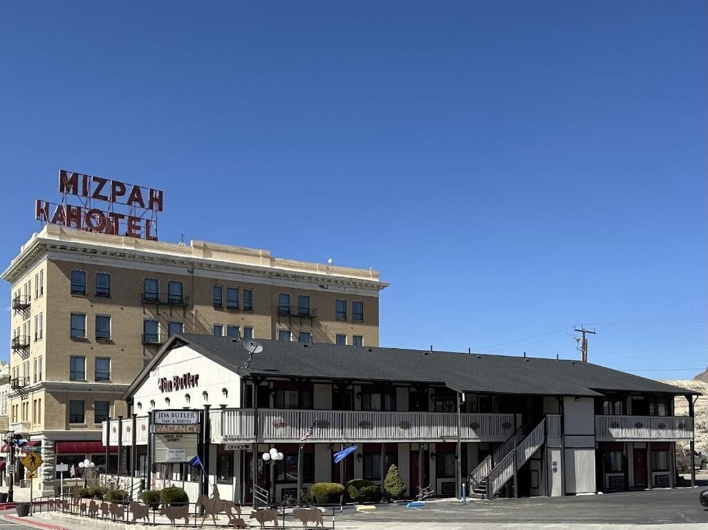 Een gebouw met een bord waarop 'Mizrah Hotel' staat en een restaurant Jim Butler.