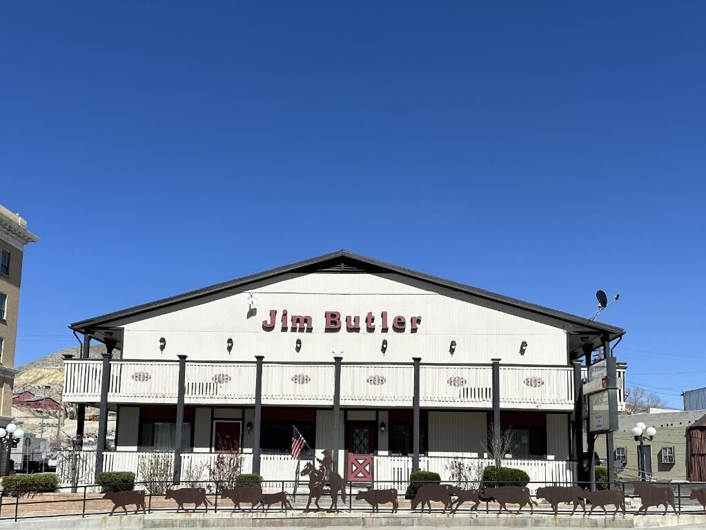 A building with a sign reading 'Jim Butler' and a horse statue in front.