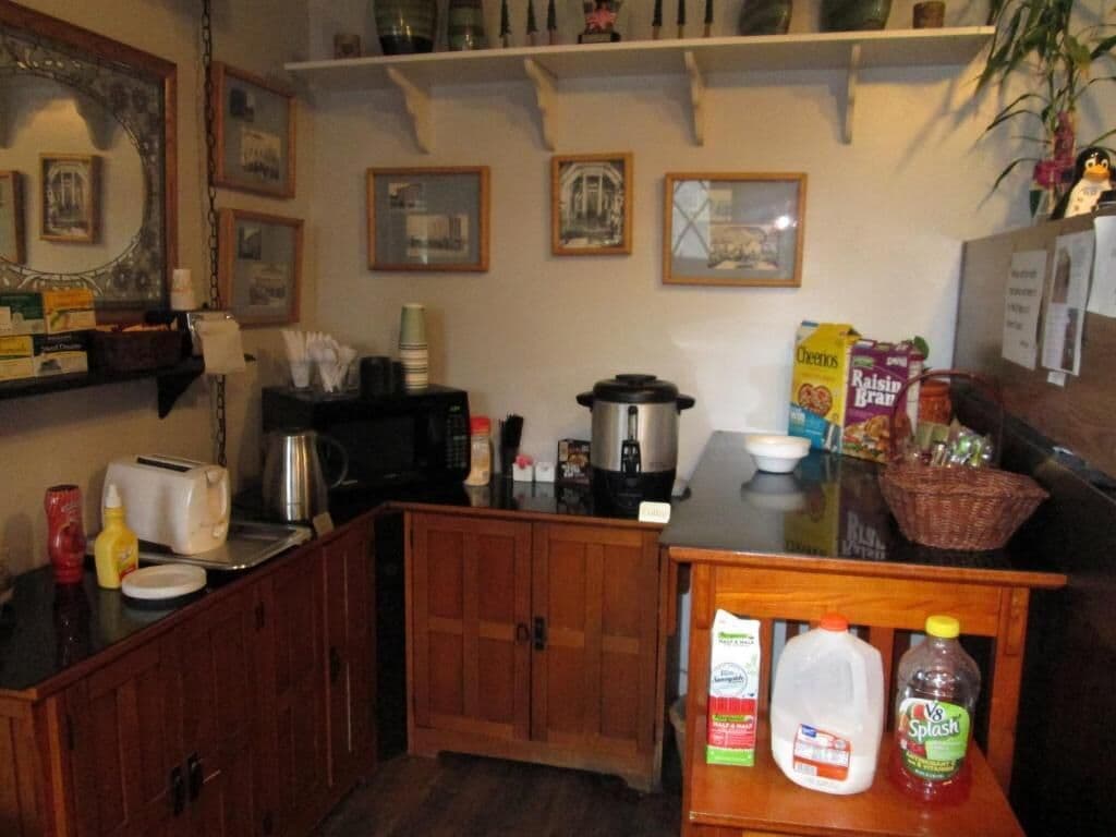 Et køkken med træskabe, kaffemaskine, brødrister og diverse fødevarer på bordet.