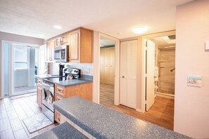 Eine Küche mit Holzausstattung, einer Mikrowelle und einer Arbeitsplatte aus Granit.