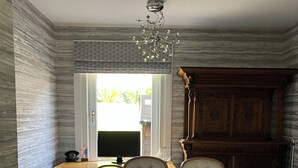 A dining area with a table, chairs, a chandelier, and a view through a window. - Beautiful 3-bedroom house. Sea view.  40 mins from Edinburgh. Dog friendly. (Burntisland)
