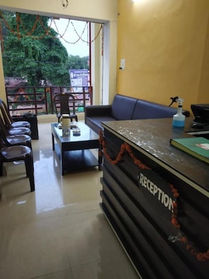 A reception area with a counter, seating, and a view of the outdoors. - Hotel Awadh Kailash (Bahraich)