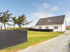 A single-story house with a grey tiled roof, a white exterior, and a gravel driveway. - "Filine" - 100m from the sea by Interhome (Løkken)