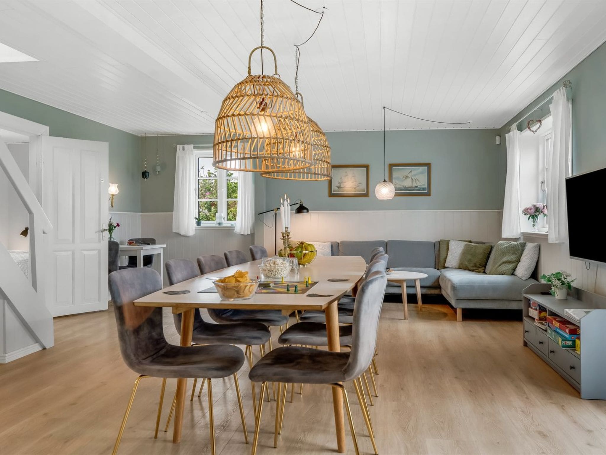 A spacious living area with a dining table, comfortable seating, and a large television.