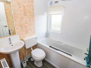 A bathroom with a toilet, sink, and bathtub. - The Lodge at Piece Farm (High Peak)