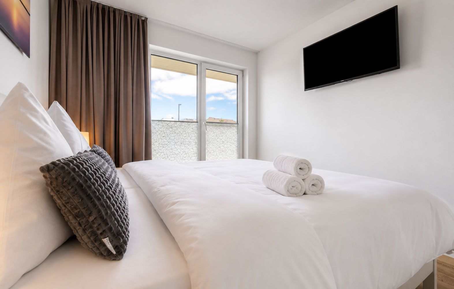 Une chambre d’hôtel avec un lit, un téléviseur à écran plat et une fenêtre donnant sur un paysage agréable.