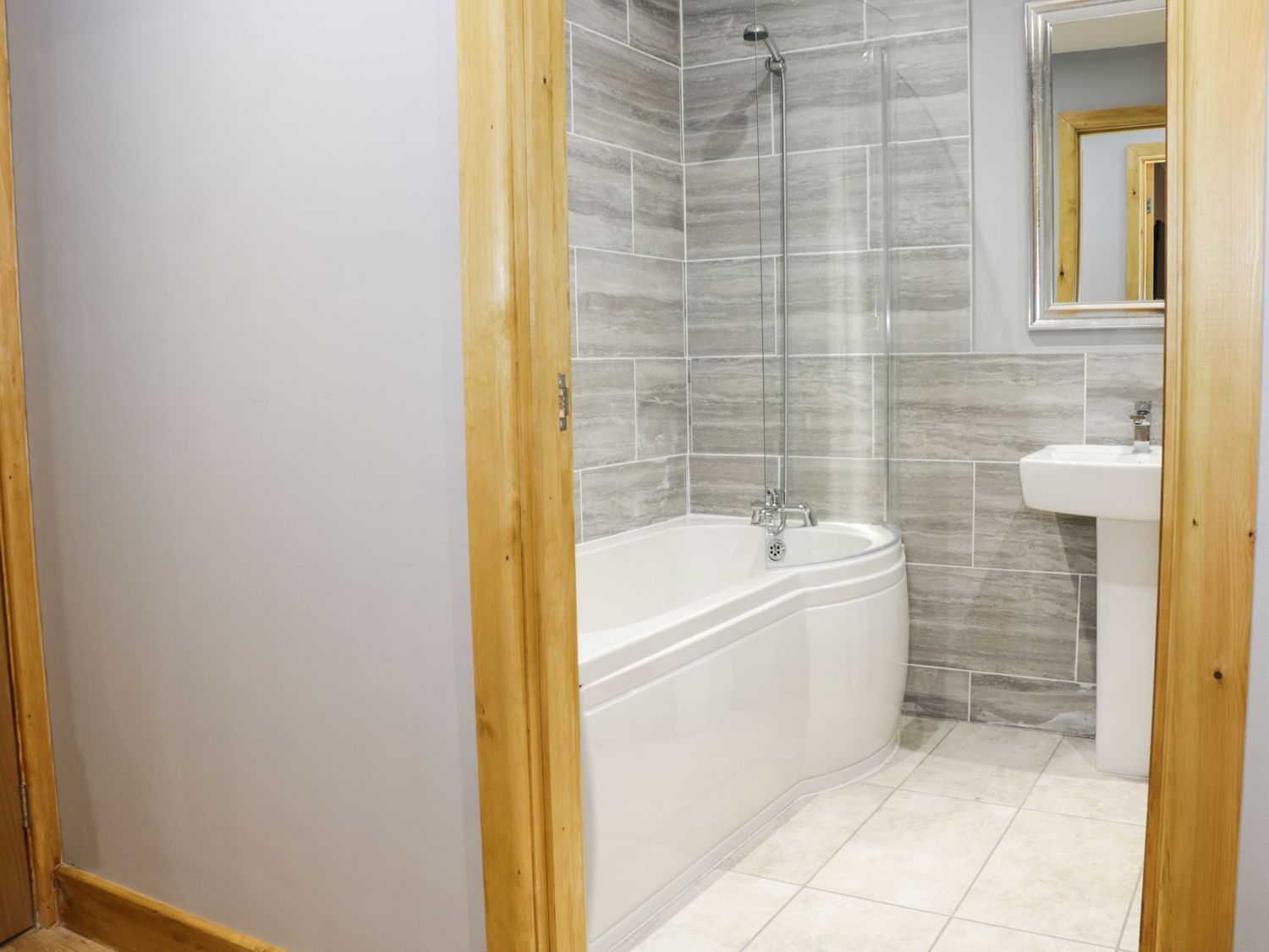 Een badkamer met een bad, douche en wastafel.