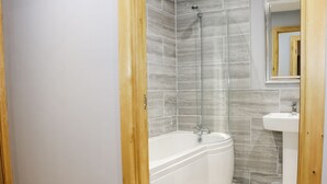 A bathroom with a bathtub, a shower, and a sink. - WOODMAN'S LODGE, family friendly, with hot tub in Nantwich (Nantwich)