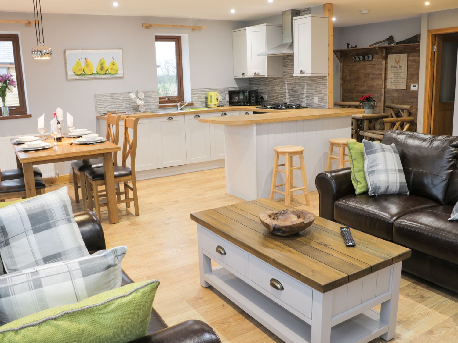 Ein modernes Wohnzimmer mit einem Couchtisch aus Holz, einer Ledersofa und einem Essbereich mit Holztisch und Stühlen.