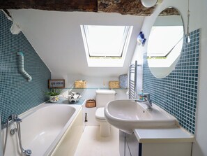 A bathroom with a skylight, a bathtub, a sink, and a toilet. - HUD Y COED, pet friendly, character holiday cottage in Llangynog (Oswestry)