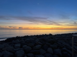 A rocky shoreline with a clear sky and a visible moon. - LYONS SUNNYSANDS - SNOWDON SUMMIT 050 in Talybont Near Bangor (Talybont)