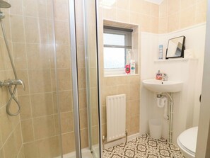 A bathroom with a shower, a sink, and a toilet.