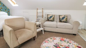 A bedroom with a bed, a sofa, a chair, a small table, and a decorative pillow. - HILL VIEW STUDIO, with a garden in Hawick (Hawick)