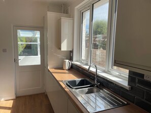 A small kitchen with a window, a sink, and a kettle. - SUMMER COTTAGE, pet friendly, with a garden in Rustington (Littlehampton)