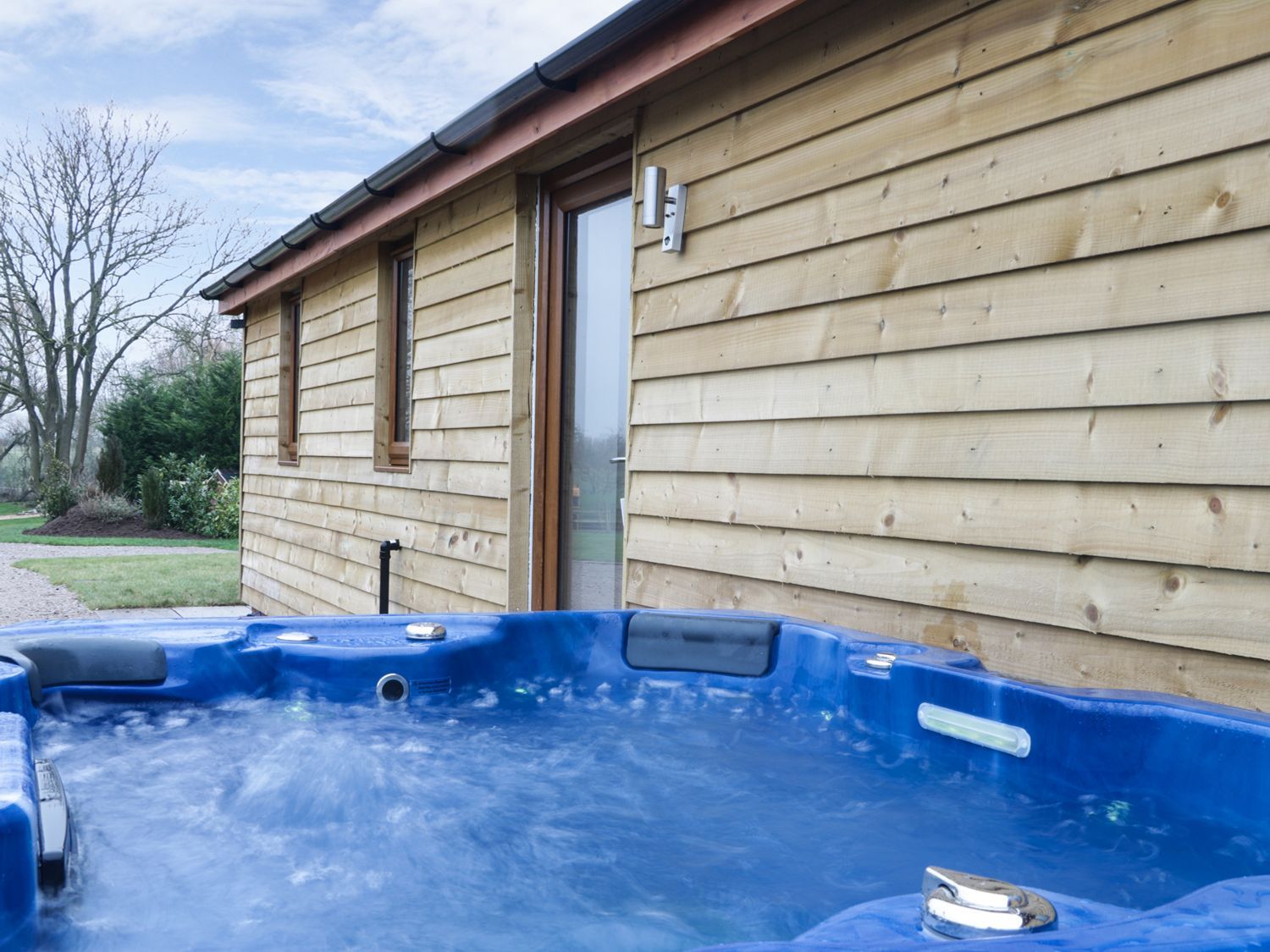 Een houten huis met een jacuzzi erbij.