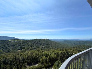 A panoramic view of a mountainous landscape with dense forest coverage and a clear sky. - 4th floor condo- amazing views- pool and hot tub (Sugar Mountain)