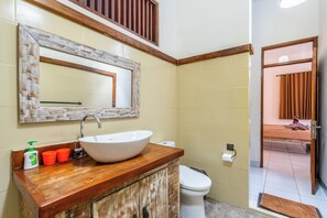 A bathroom with a wooden vanity, a large mirror, a white sink, and a toilet. - Just a few min stroll to the Seminyak beach (Bali)