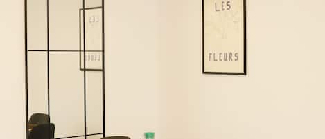 Un comedor moderno con una mesa redonda, cuatro sillas y una obra de arte enmarcada en la pared.