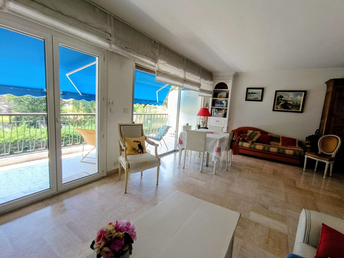 Ampla sala de estar com varanda, conjunto de jantar e sofá.