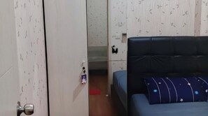Ein Schlafzimmer mit Bett, Schrank und einer Tür zu einem Badezimmer.