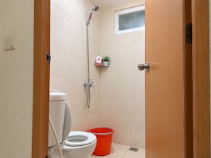 Un bany petit amb vàter, dutxa i finestra.