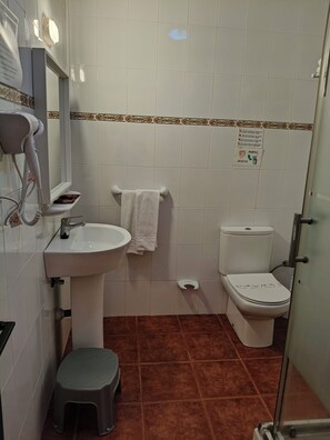 A bathroom with a sink, toilet, and a hairdryer.
