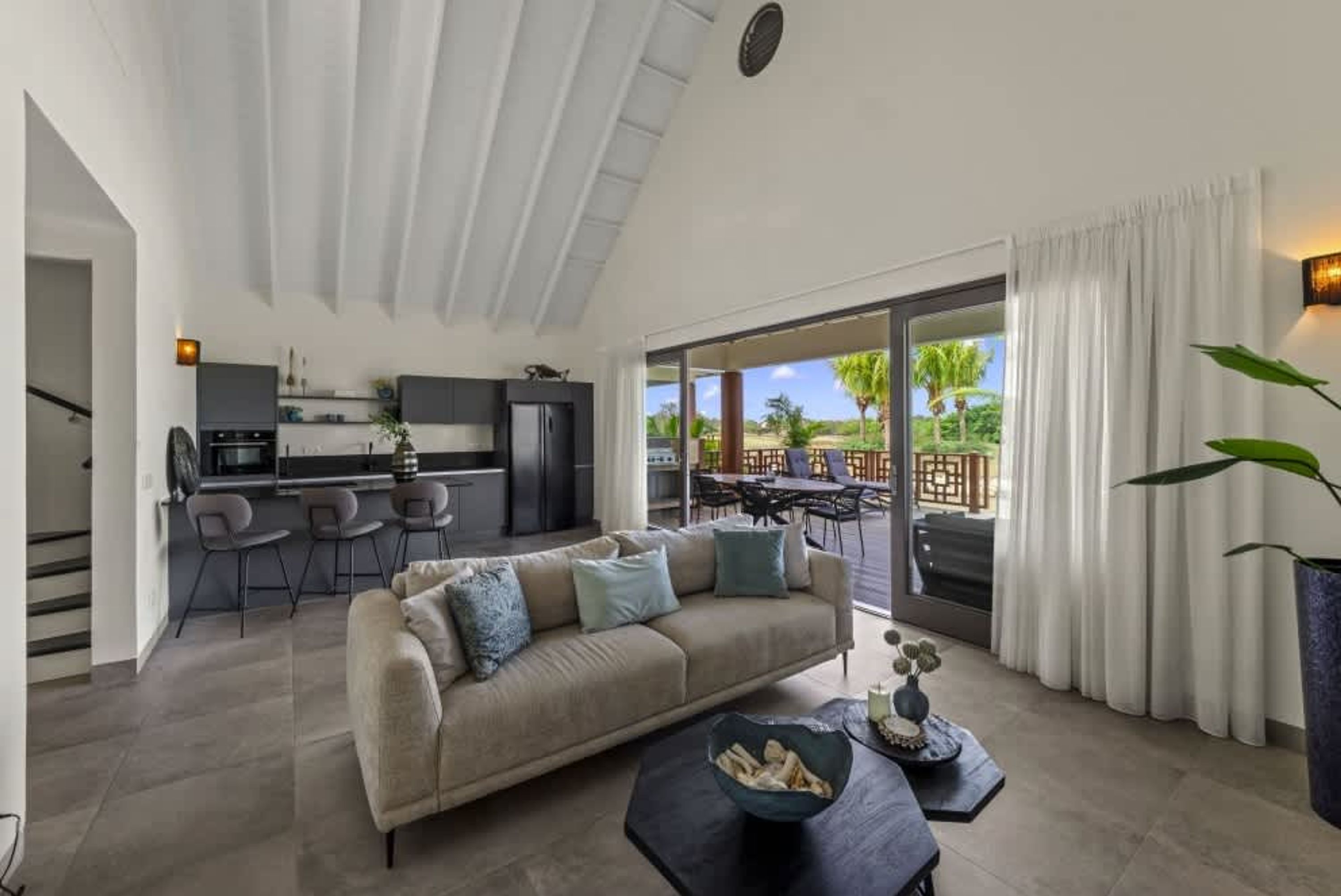 Ein modernes Wohnzimmer mit einer Couch, einem Couchtisch und Blick auf die Außenpatio-Terrasse.