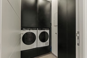 A laundry room with two front-loading washing machines and a door. - Villa Zaya Blue Bay Private Pool Golf View (Sint Michiel)
