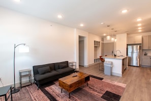 Un apartamento moderno con sala de estar, kitchenette y comedor.