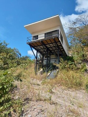A single-story building with a flat roof, elevated on stilts, surrounded by vegetation. - w Cozy 2BR Near Playa Grande w Mountain Views (Cabo Velas)