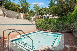 Une piscine rectangulaire avec un bord carrelé et un escalier en métal.