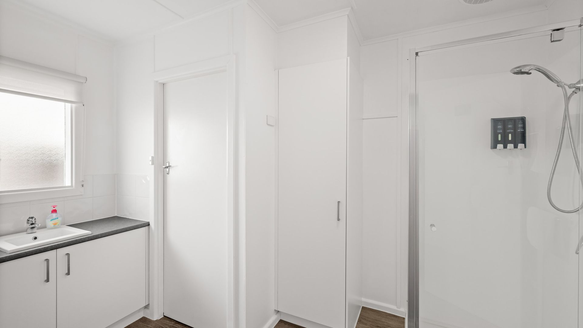 A modern bathroom with a shower, a toilet, and a sink.