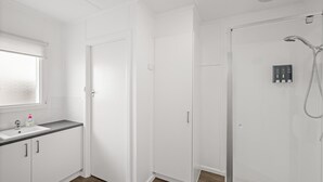 A modern bathroom with a shower, a toilet, and a sink. - Phillip Island Cottage 2 (Cowes)