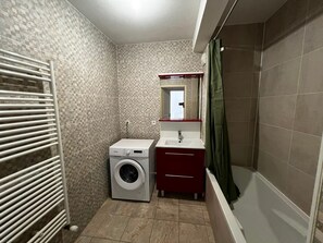 A compact bathroom with a washing machine, a sink, and a shower. - Cosy apartment in city centre - 4 guests (La Teste-de-Buch)