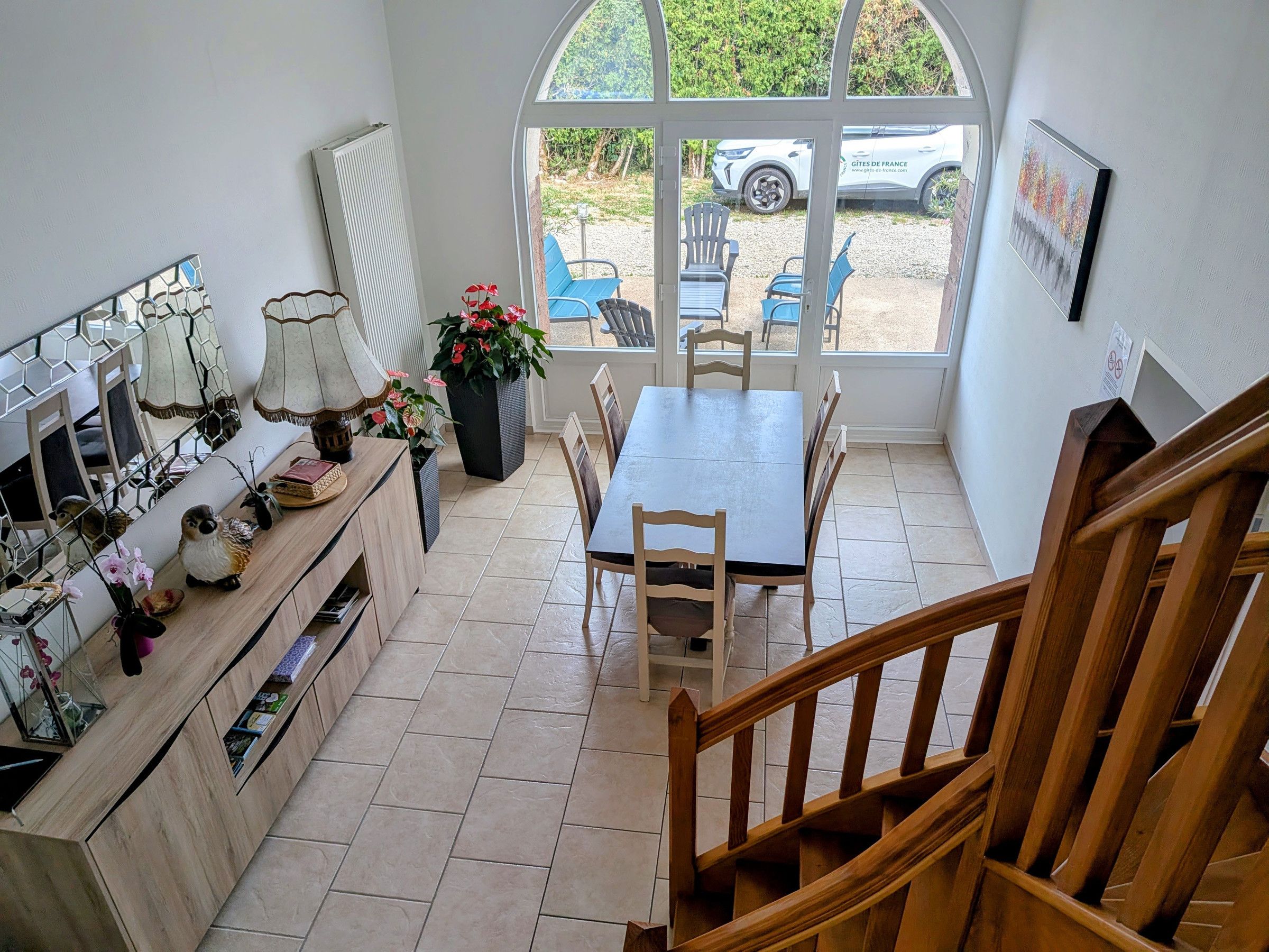 A dining area with a table and chairs, a wooden bench, and a potted plant.